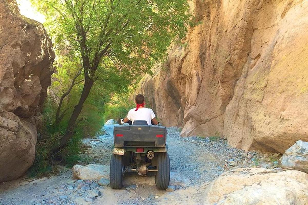 a man riding a quad bike on a rocky trail