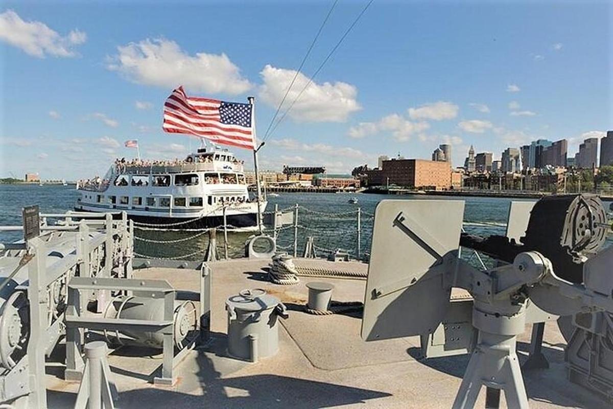 a boat in the water with a flag and a ship