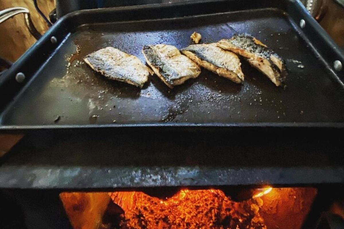 Cuatro piezas de comida cocinándose en una parrilla