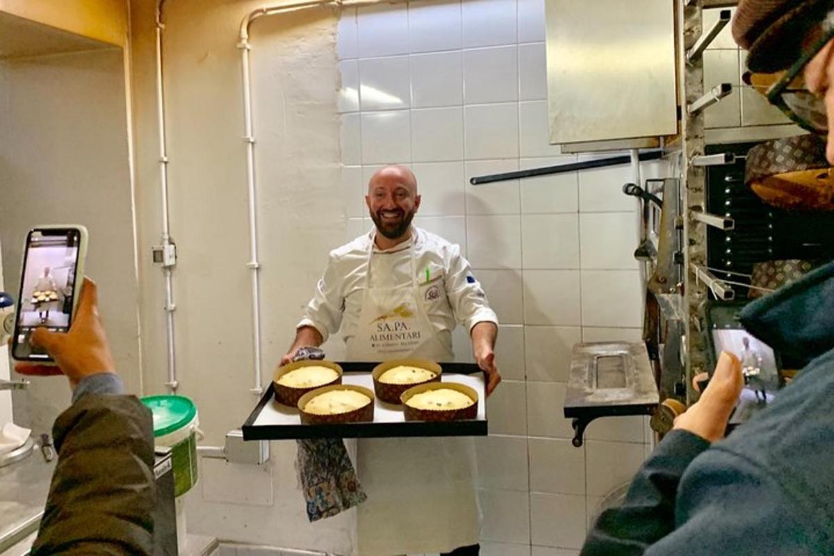 a man in a kitchen holding a tray of food