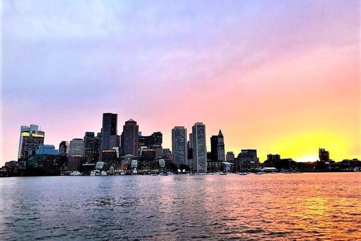 a view of a city from the water at sunset