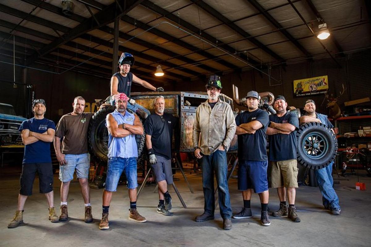 a group of men standing in front of a truck