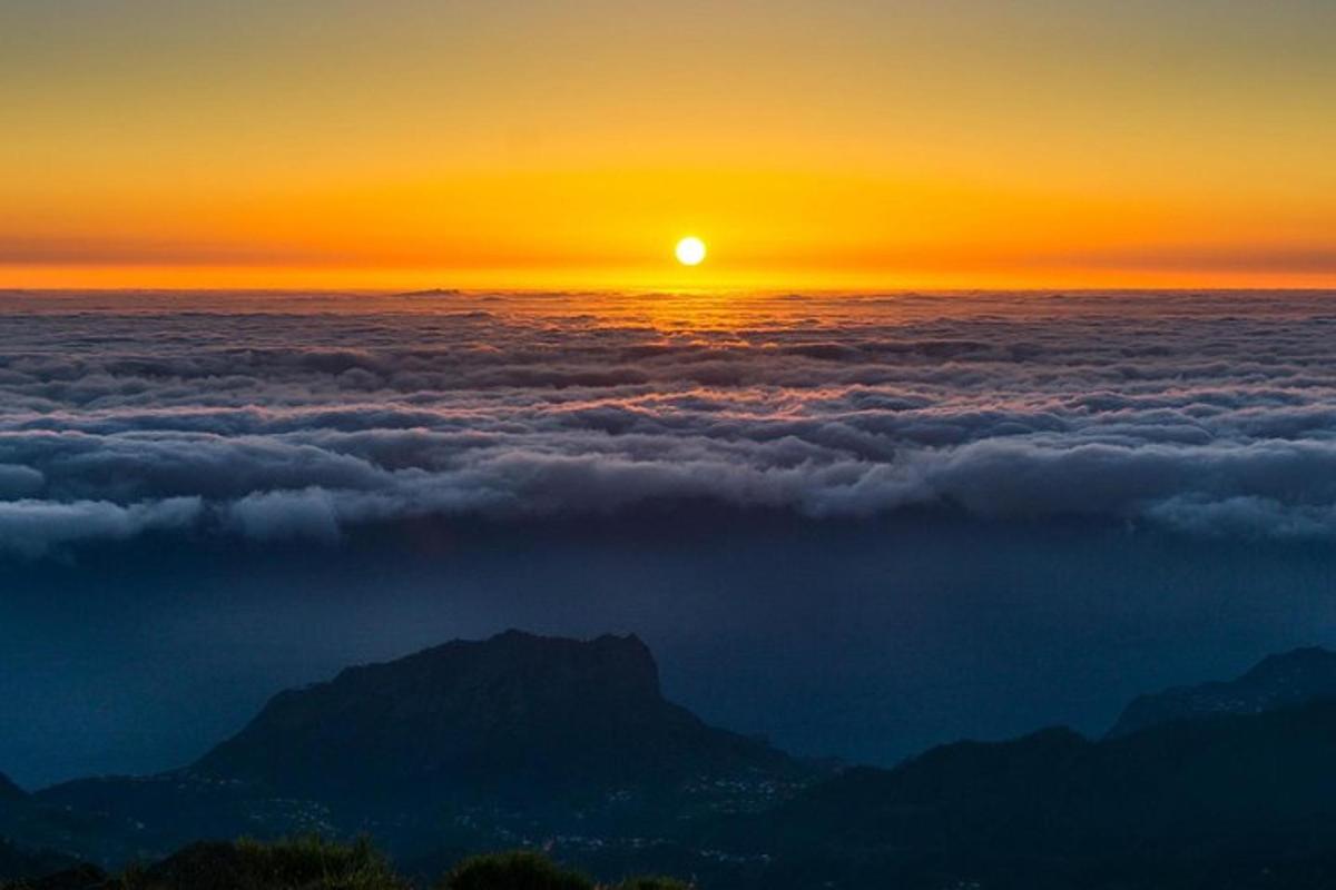 ein Blick auf die Sonne, die über einer Wolkenschicht aufgeht