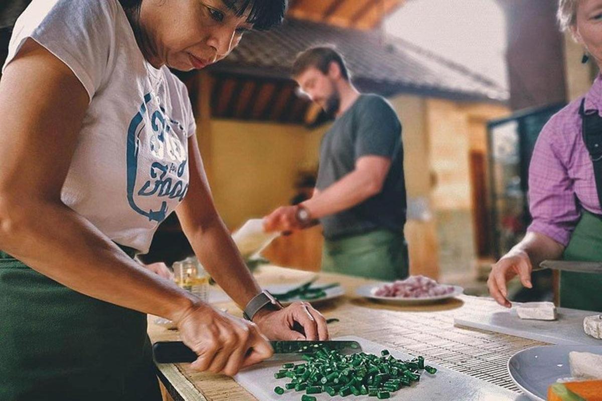 a woman cutting up greens on a cutting board