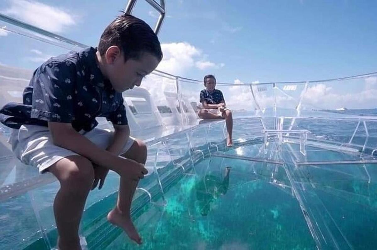 mladý chlapec sedící na skleněné podlaze lodi