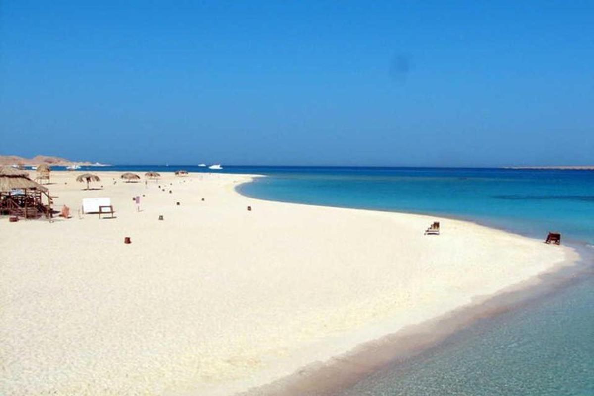 eine Gruppe von Menschen an einem Strand mit Blick auf das Meer
