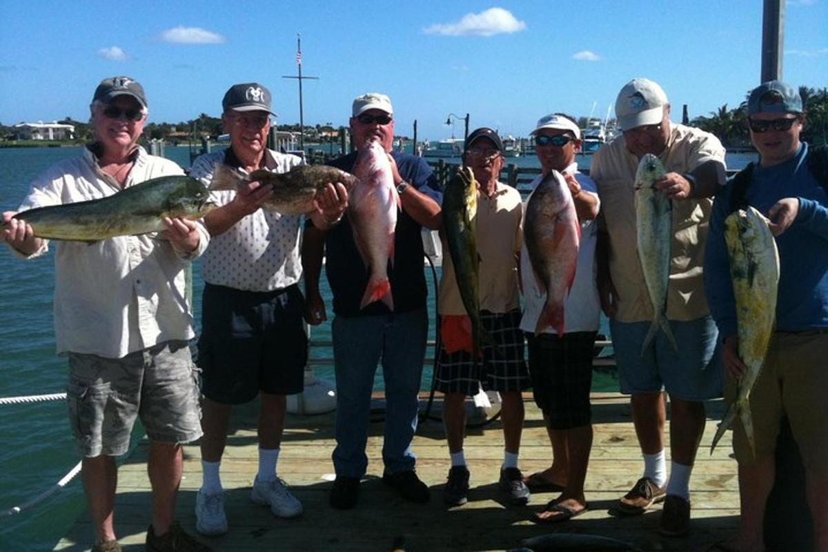 a group of people holding fish on a boat