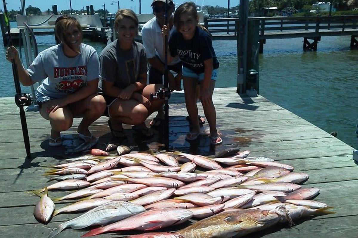 a group of people standing next to a large group of fish