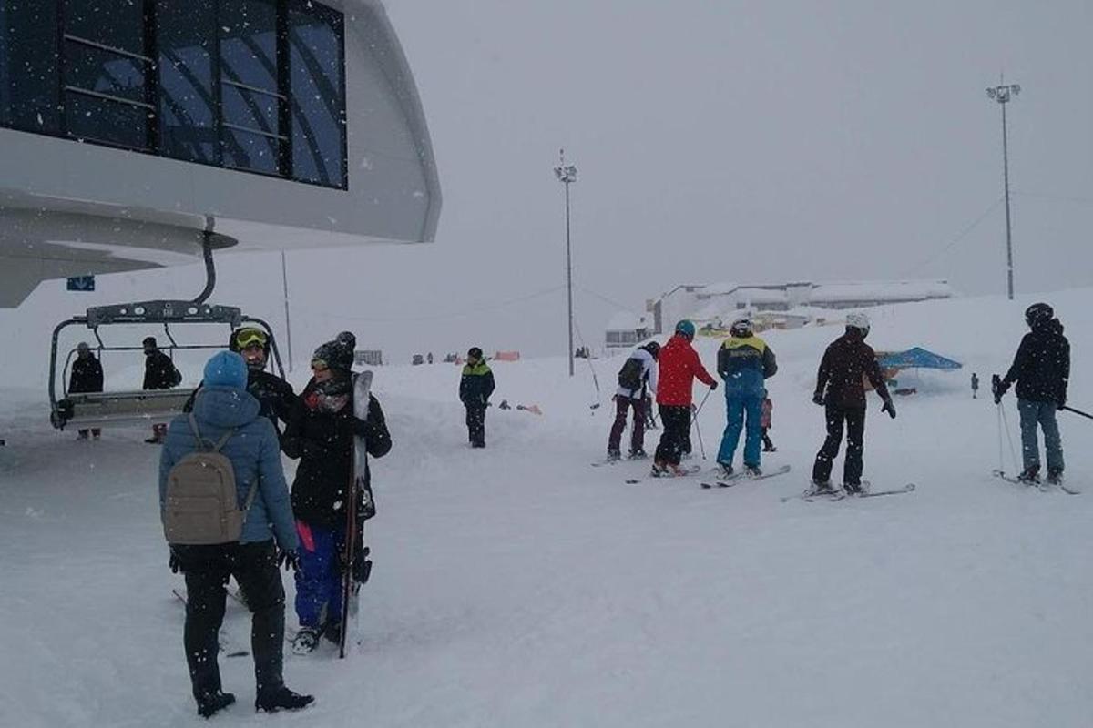 un grup de oameni care stăteau în zăpadă lângă un teleschi