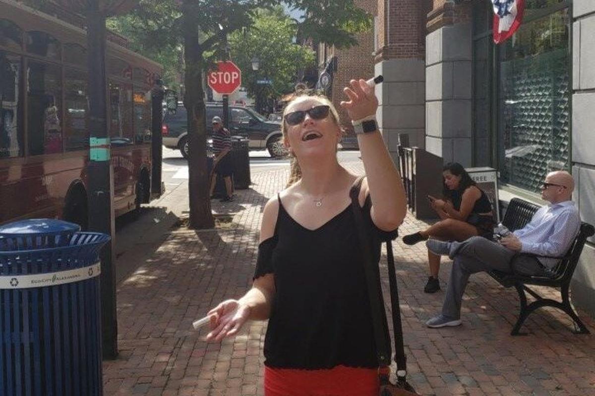 uma mulher jogando videogame em uma rua da cidade