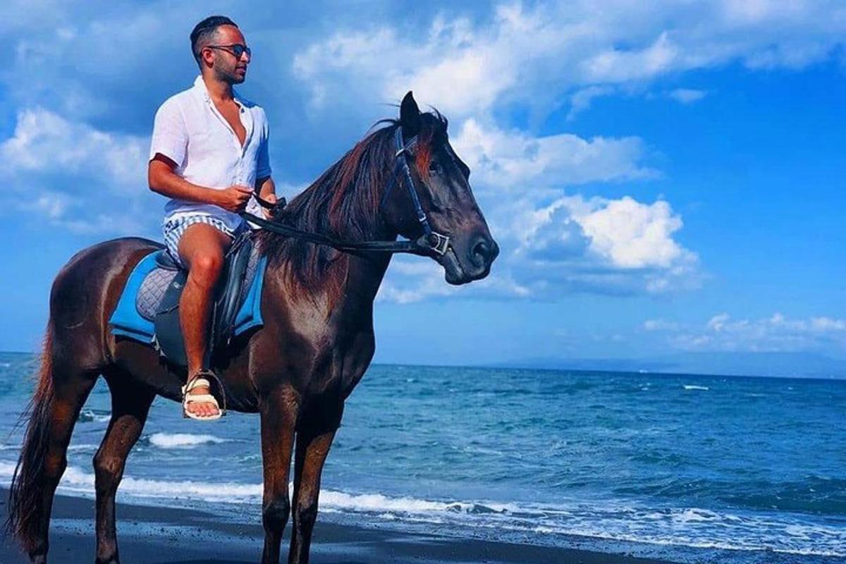 seorang lelaki menunggang kuda di pantai