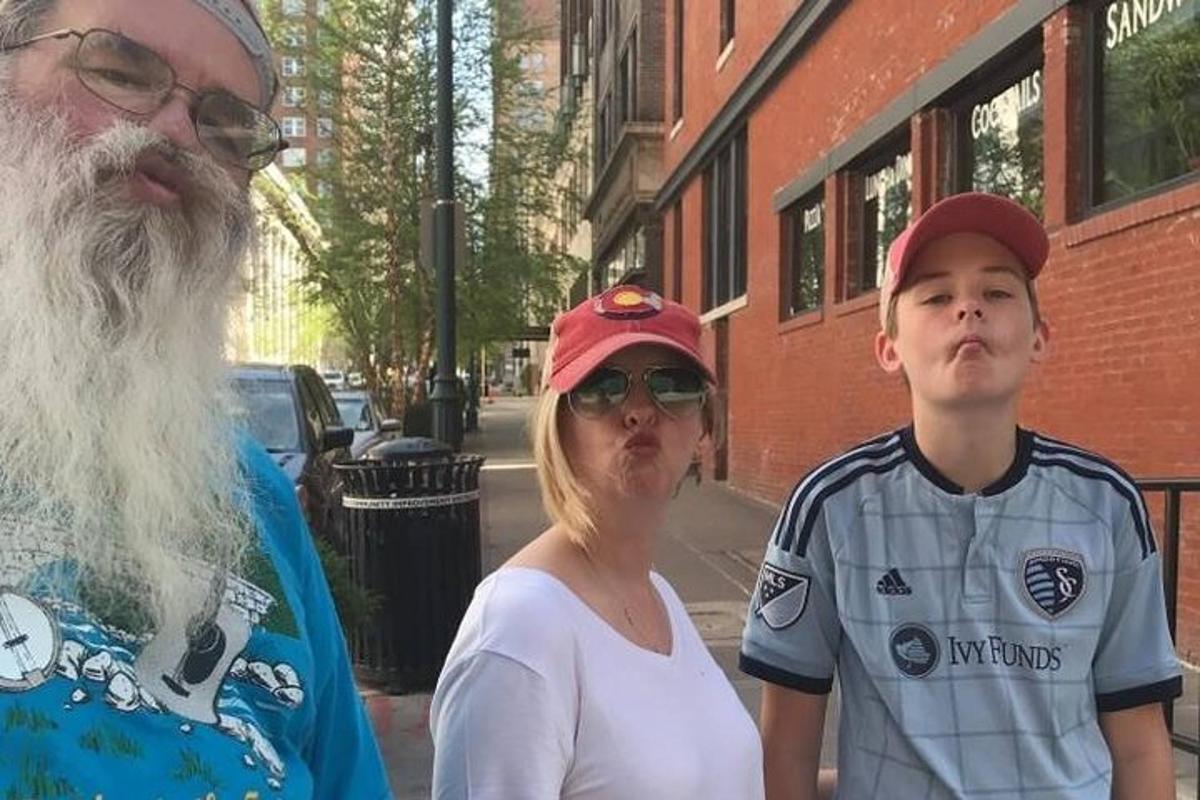 une femme et un homme debout à côté d'un garçon