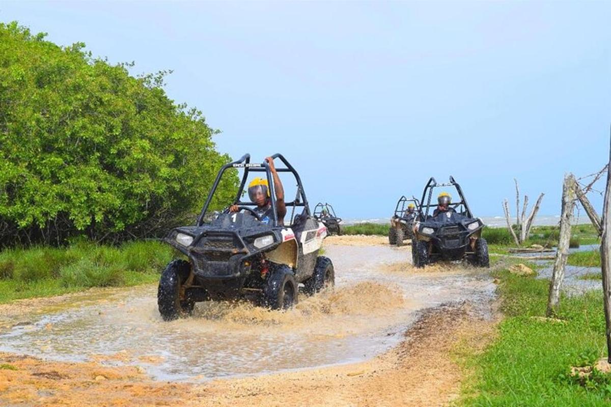 泥だらけの未舗装道路でATVに乗っている2人