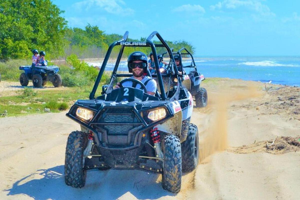 due persone in sella a un quad sulla spiaggia