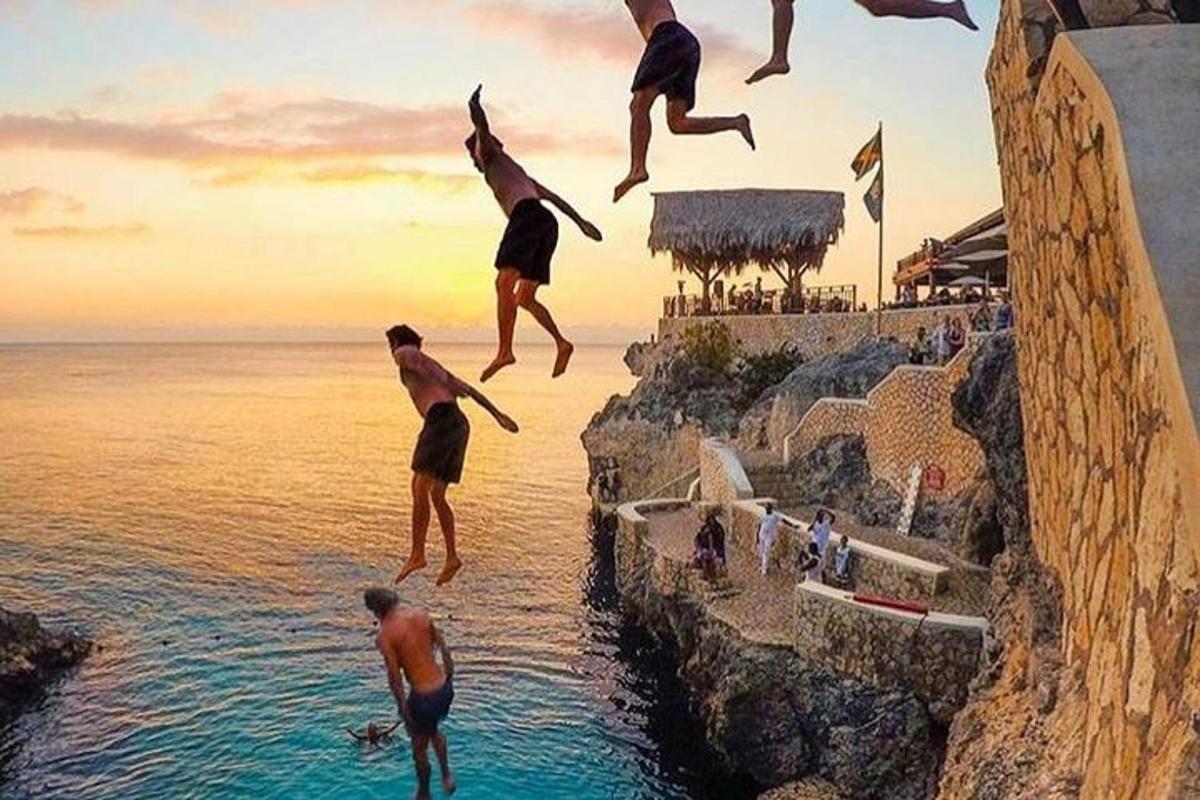 Un grupo de hombres saltando de un acantilado al agua.