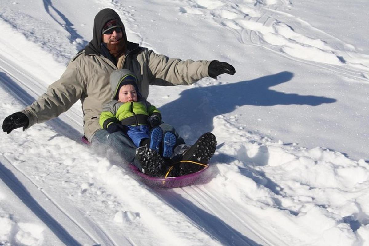 um homem e uma criança em uma prancha de snowboard na neve