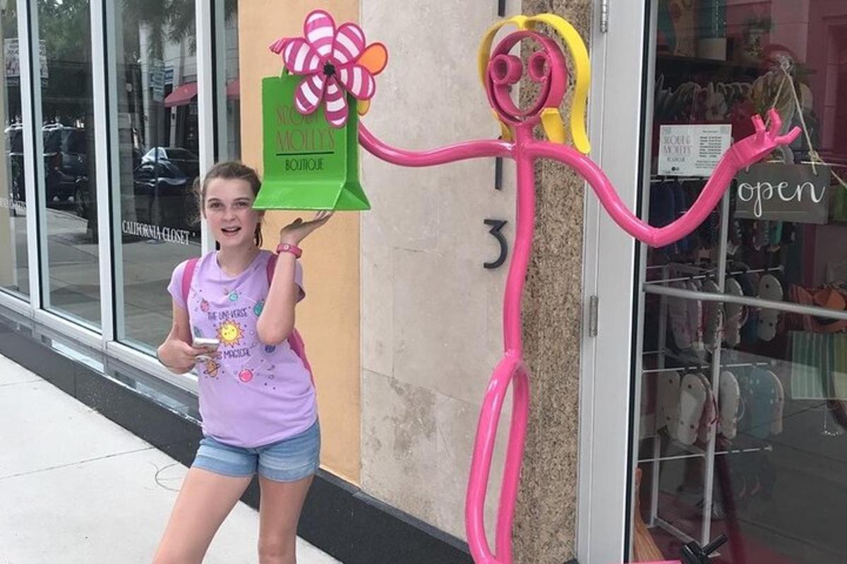 en ung pige holder et skilt op foran en butik