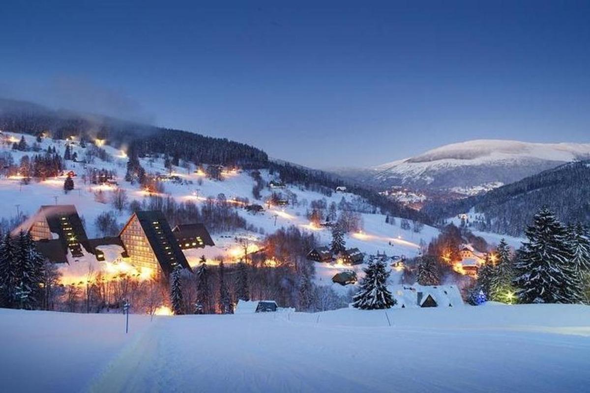 uma cidade na neve à noite com luzes