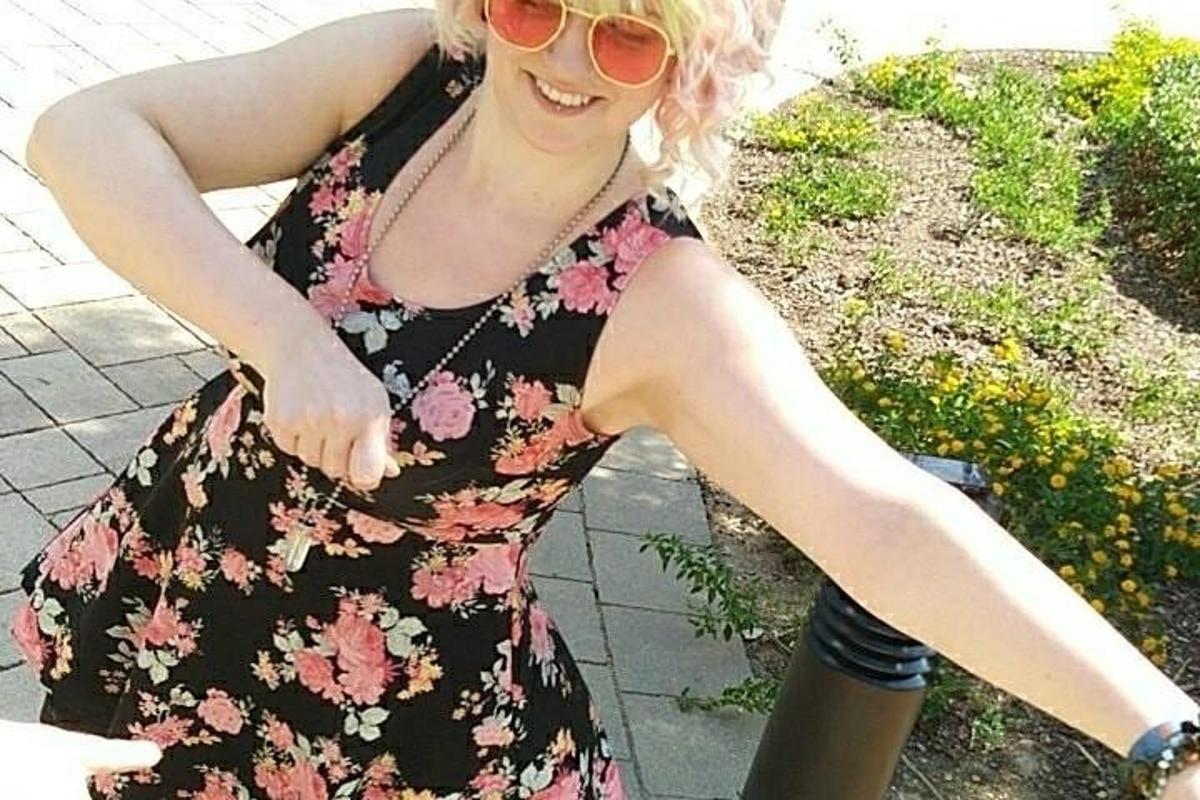 Una mujer con un vestido floral y gafas de sol.