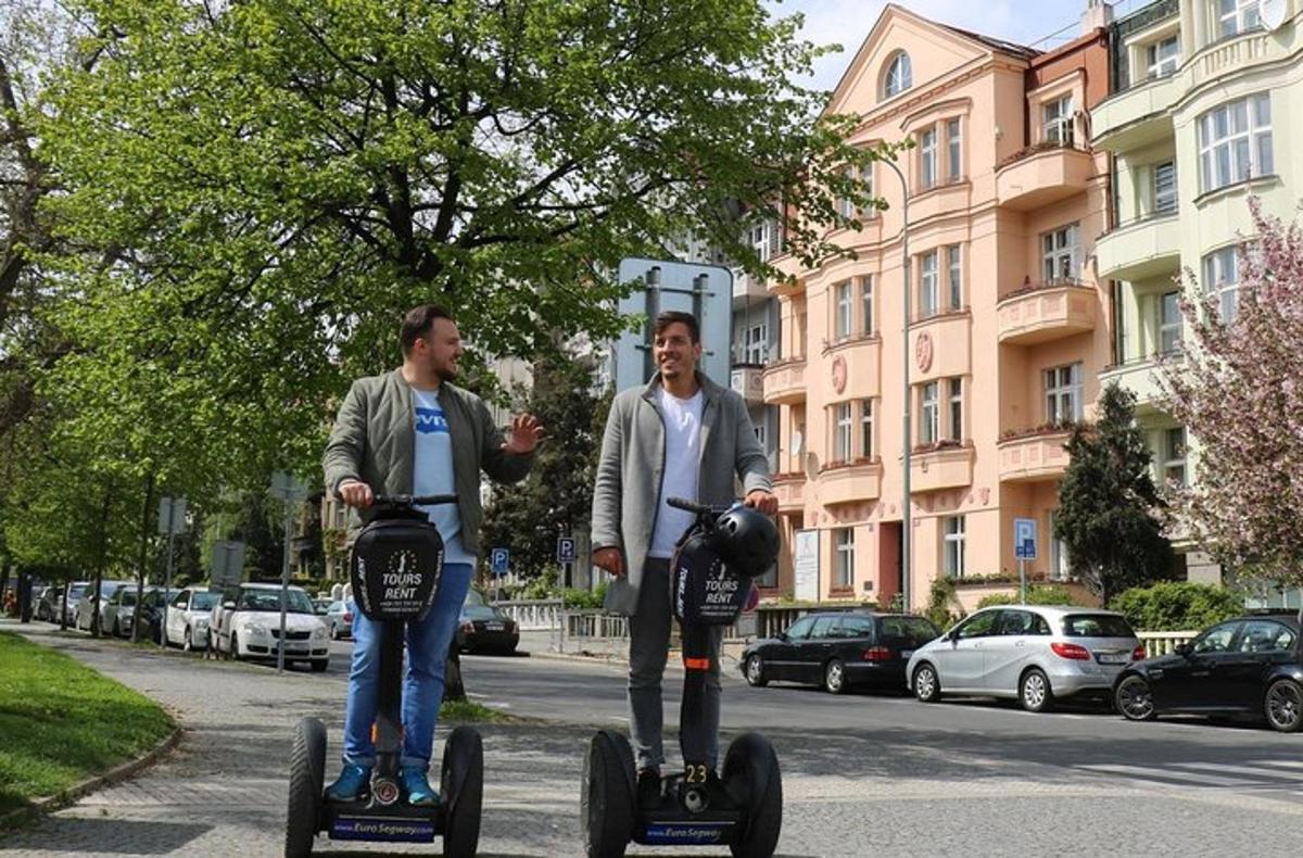 due uomini stanno guidando dei segway lungo una strada