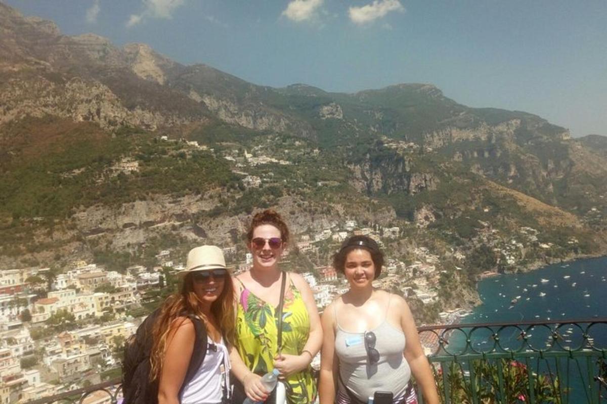 Un grupo de tres mujeres de pie en la cima de una montaña.