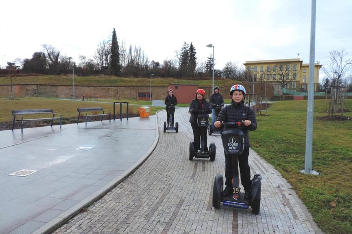 a group of children riding on segways in a park