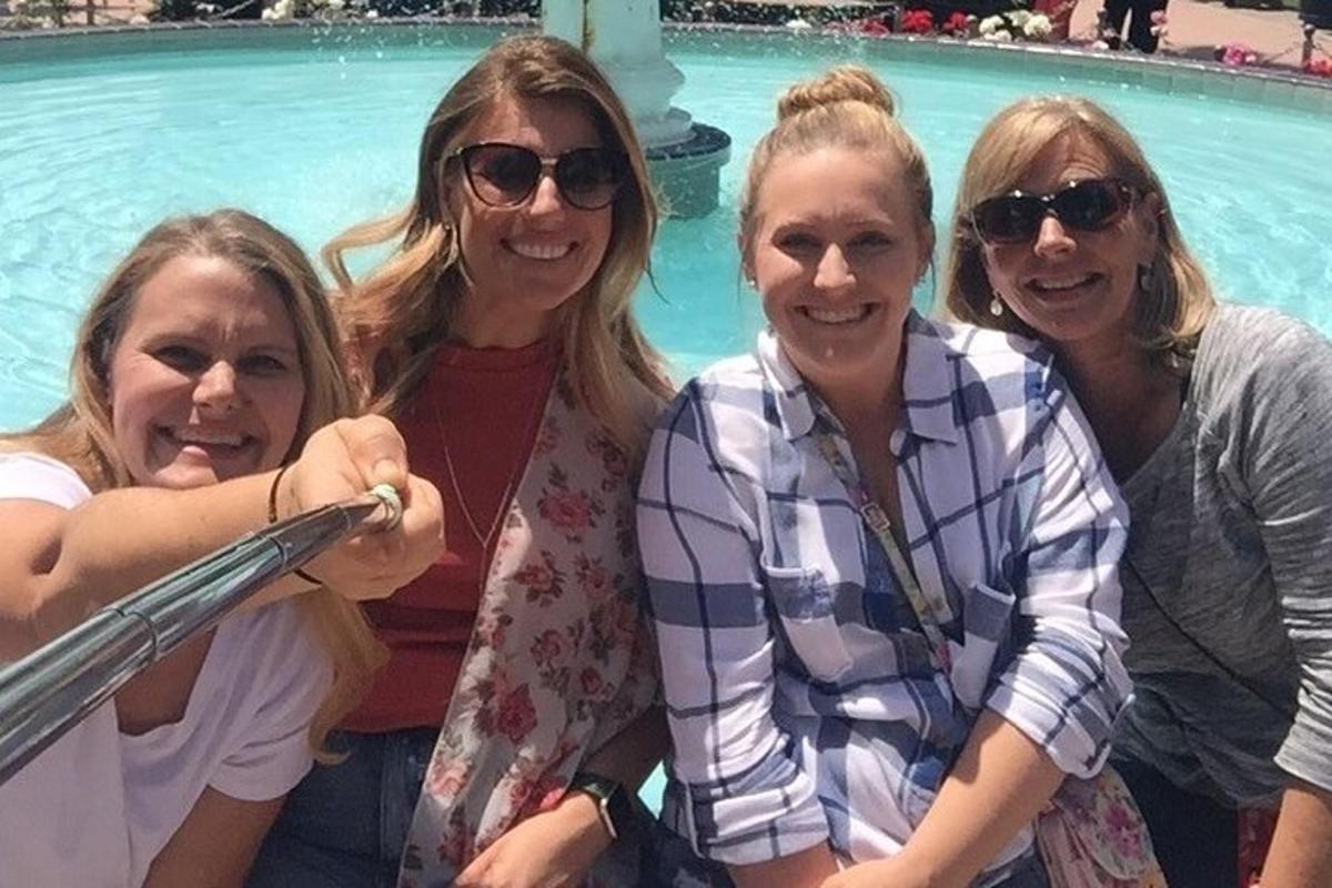 um grupo de mulheres em pé em frente a uma piscina