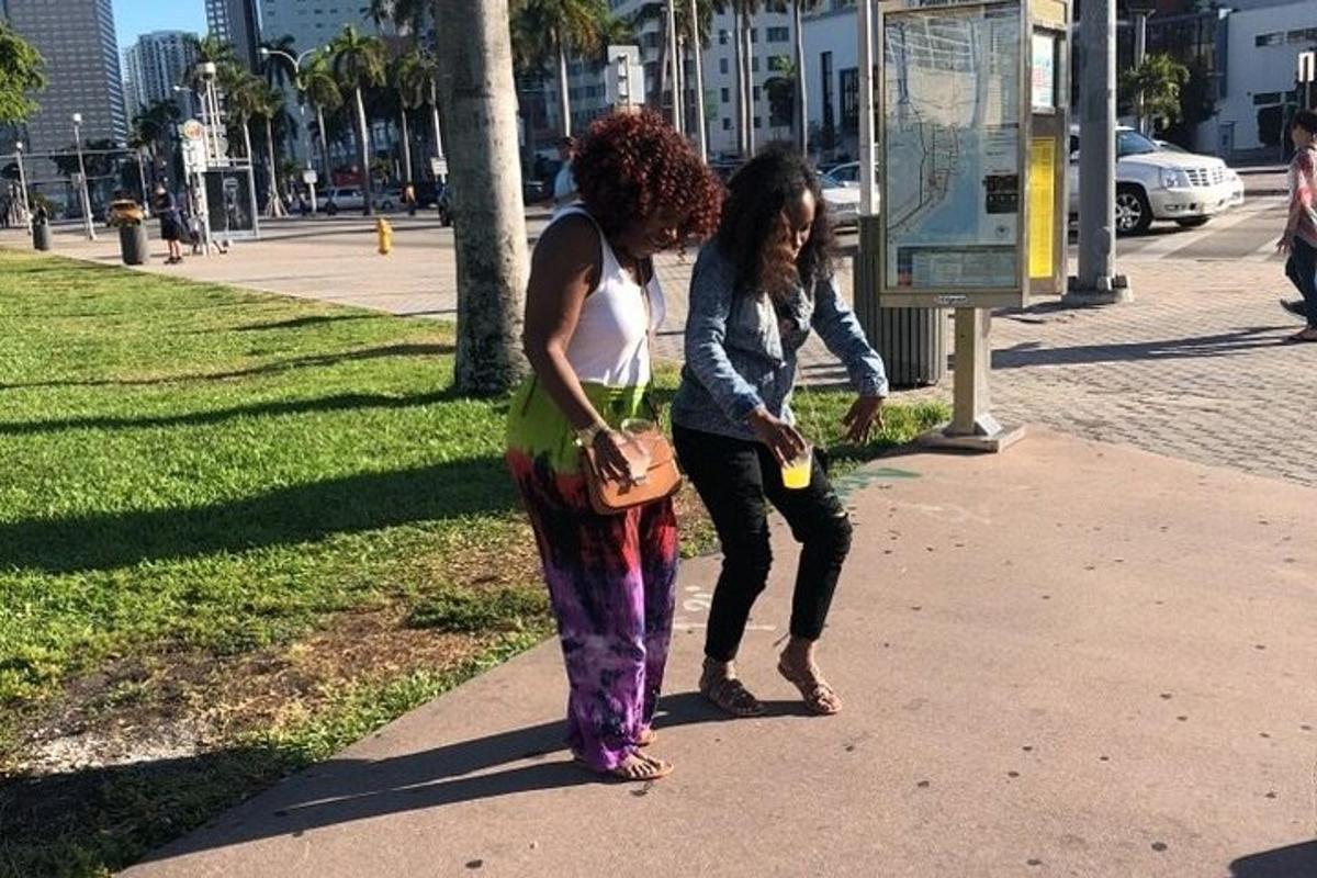 duas mulheres em pé na calçada de um parque