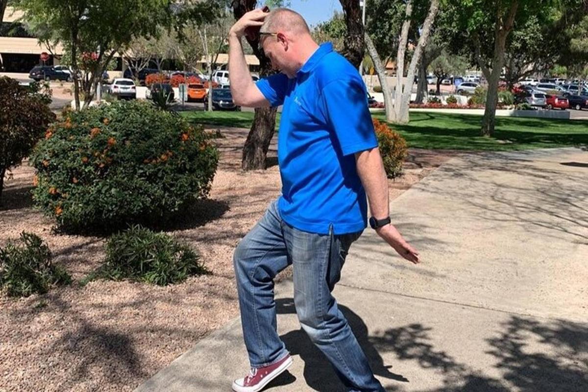 seorang pria berbaju biru sedang melempar frisbee