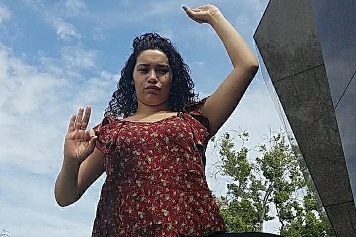 una dona dreta amb els braços enlaire