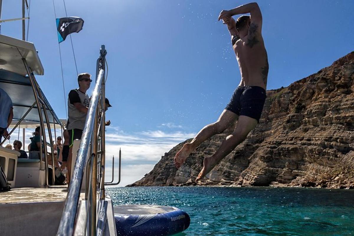 un hombre saltando al agua desde un bote