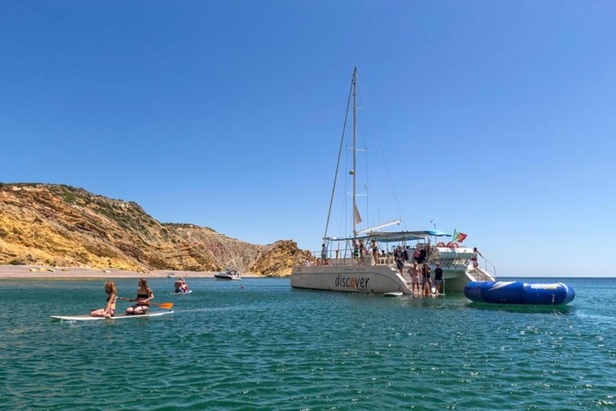 Un grupo de personas en tablas de surf en el agua cerca de un barco.