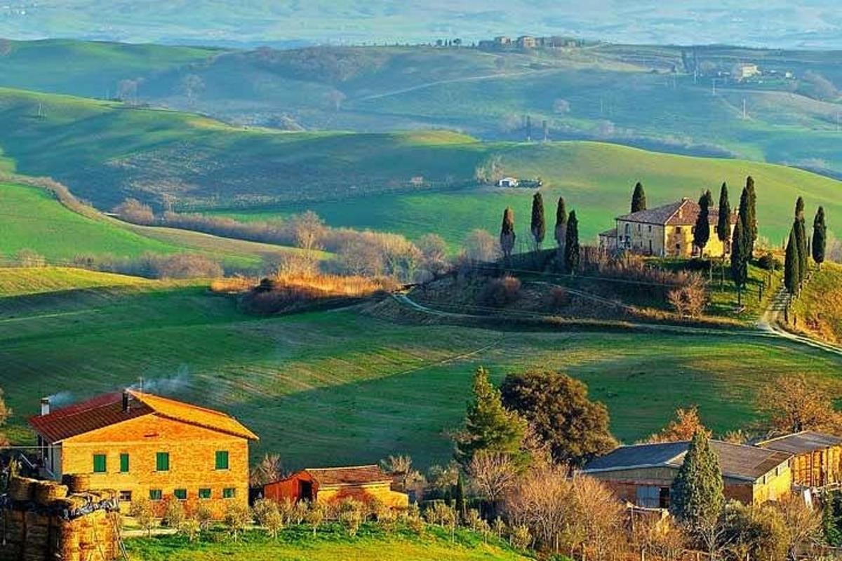 Un campo verde con una casa en una colina