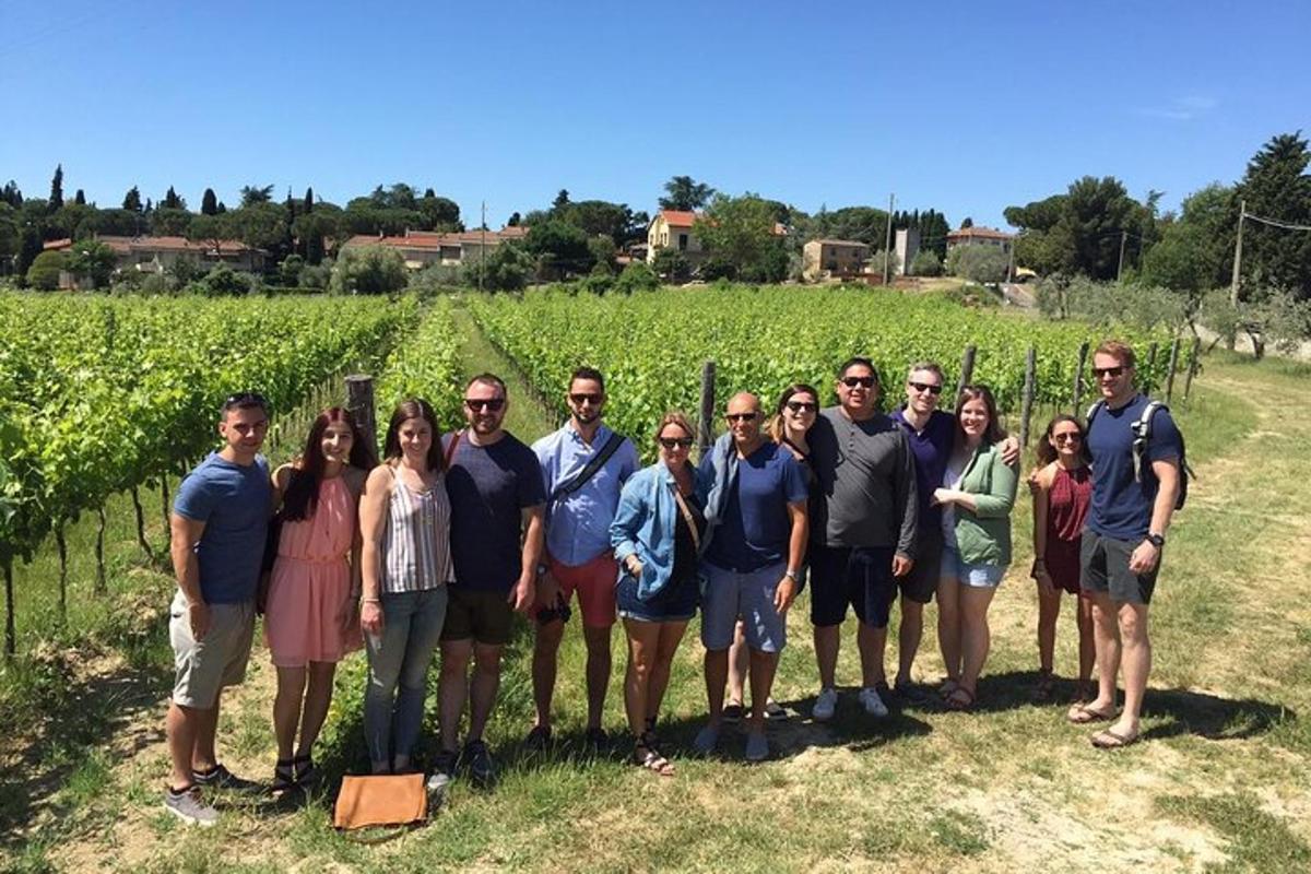 a group of people standing in front of a vineyard