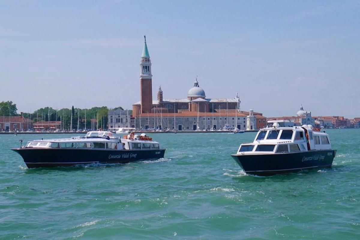 dois barcos na água com uma cidade ao fundo