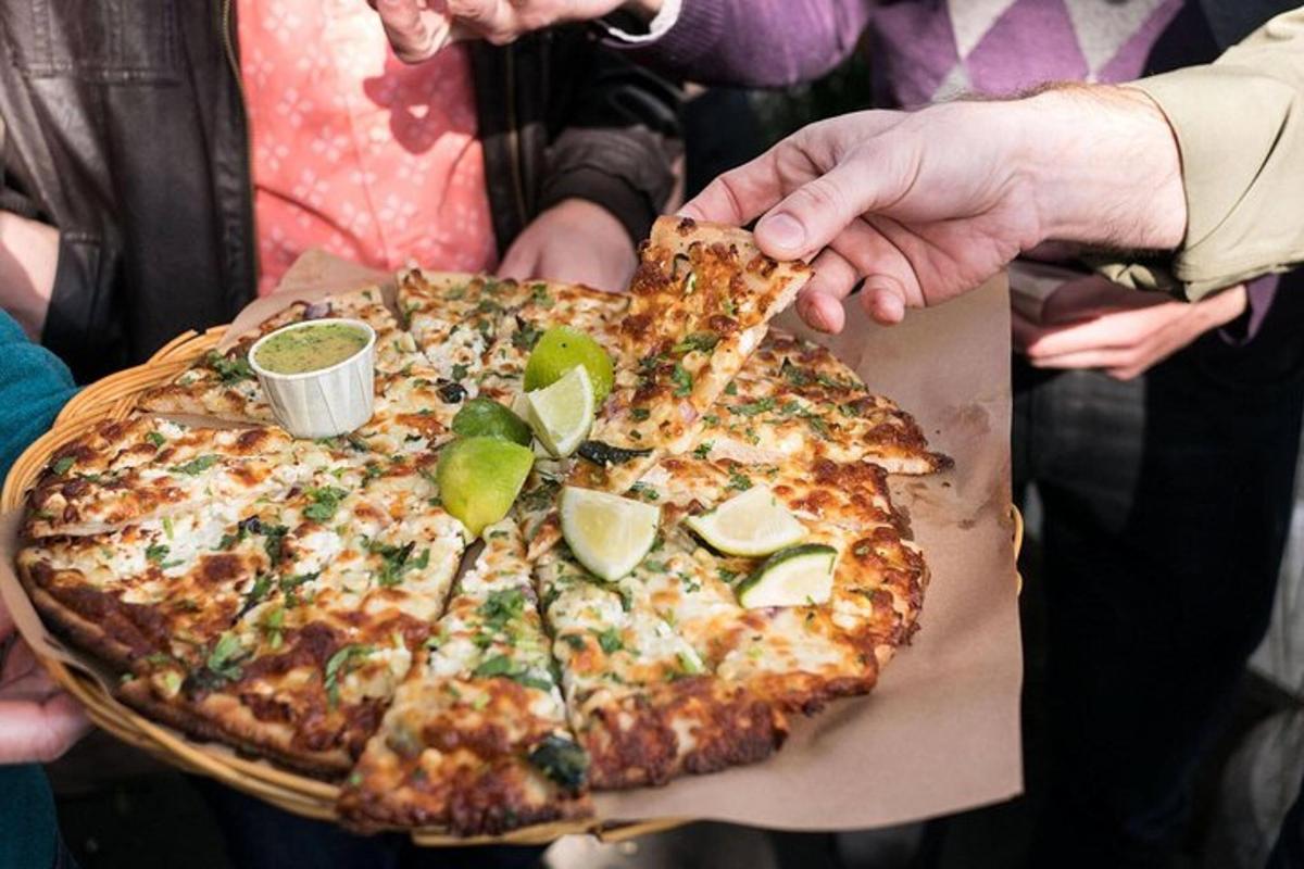 uma pessoa segurando uma pizza grande com fatias de limão