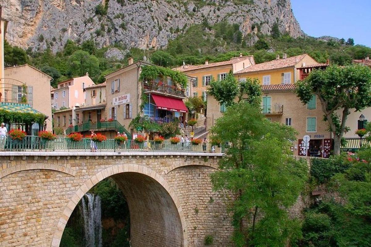 a bridge over a river in a town with a mountain