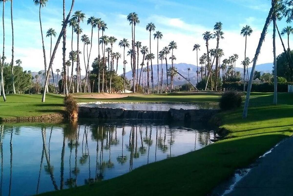 padang golf dengan pokok palma dan kolam