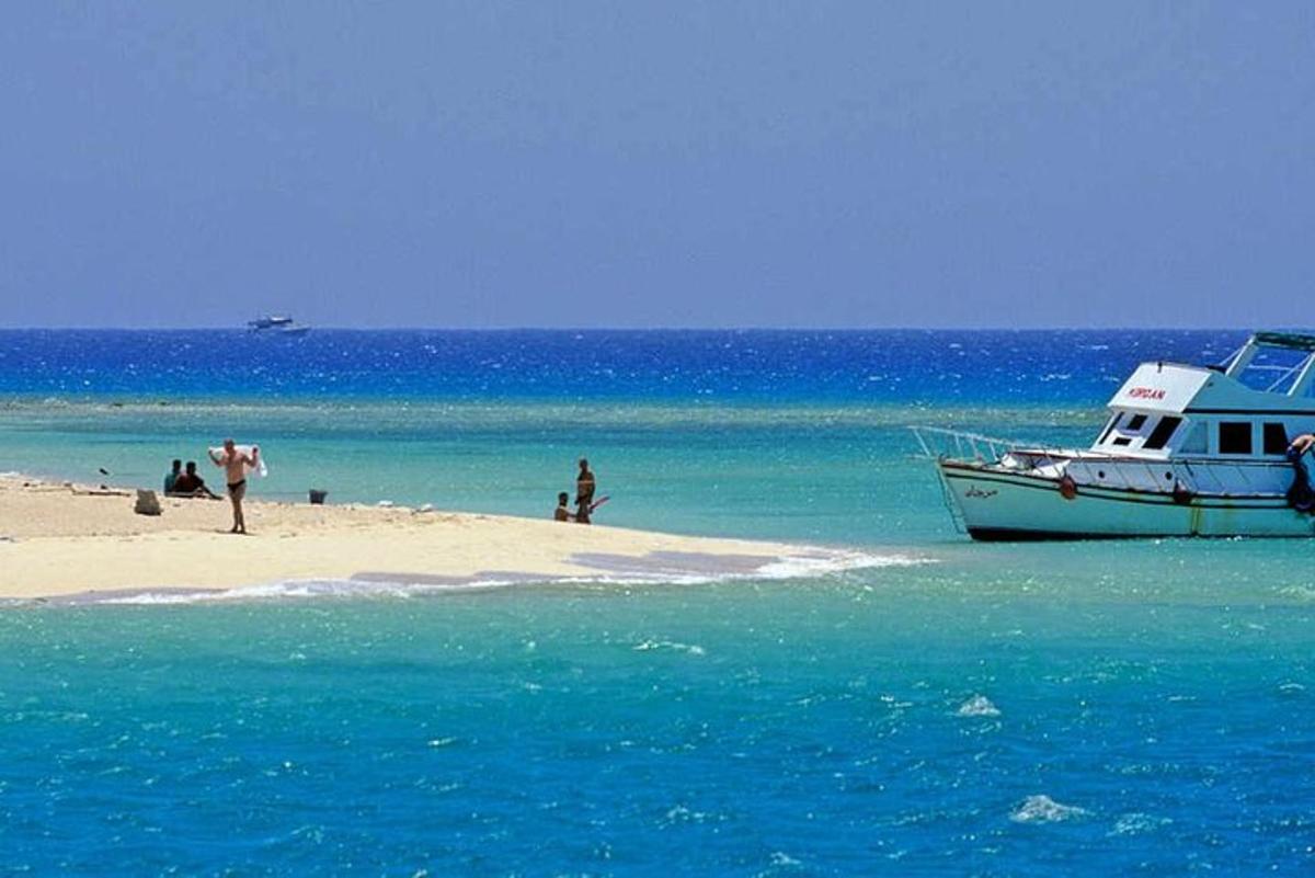 un vaixell assegut a la platja vora l'oceà