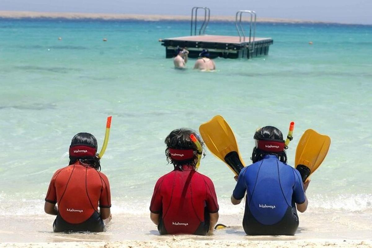 un grup de persones assegudes a la platja amb caiacs