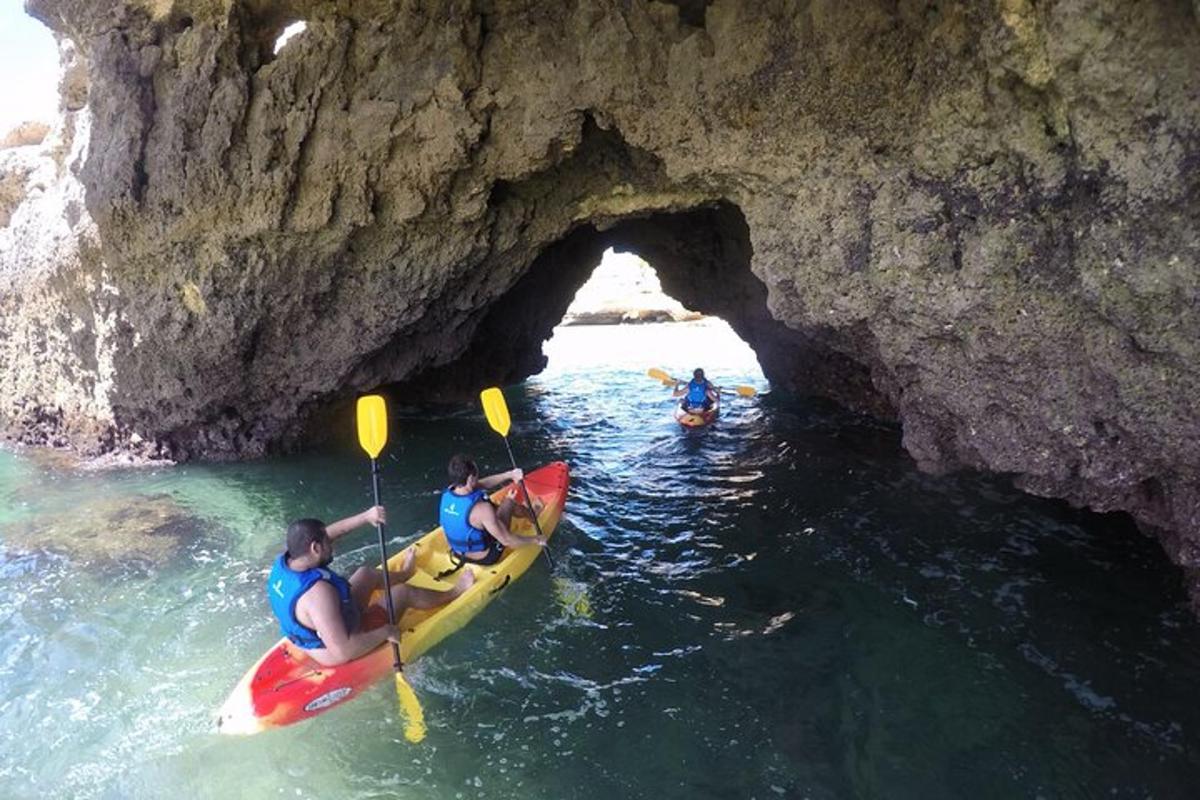 một nhóm người chèo thuyền kayak trước một hang động
