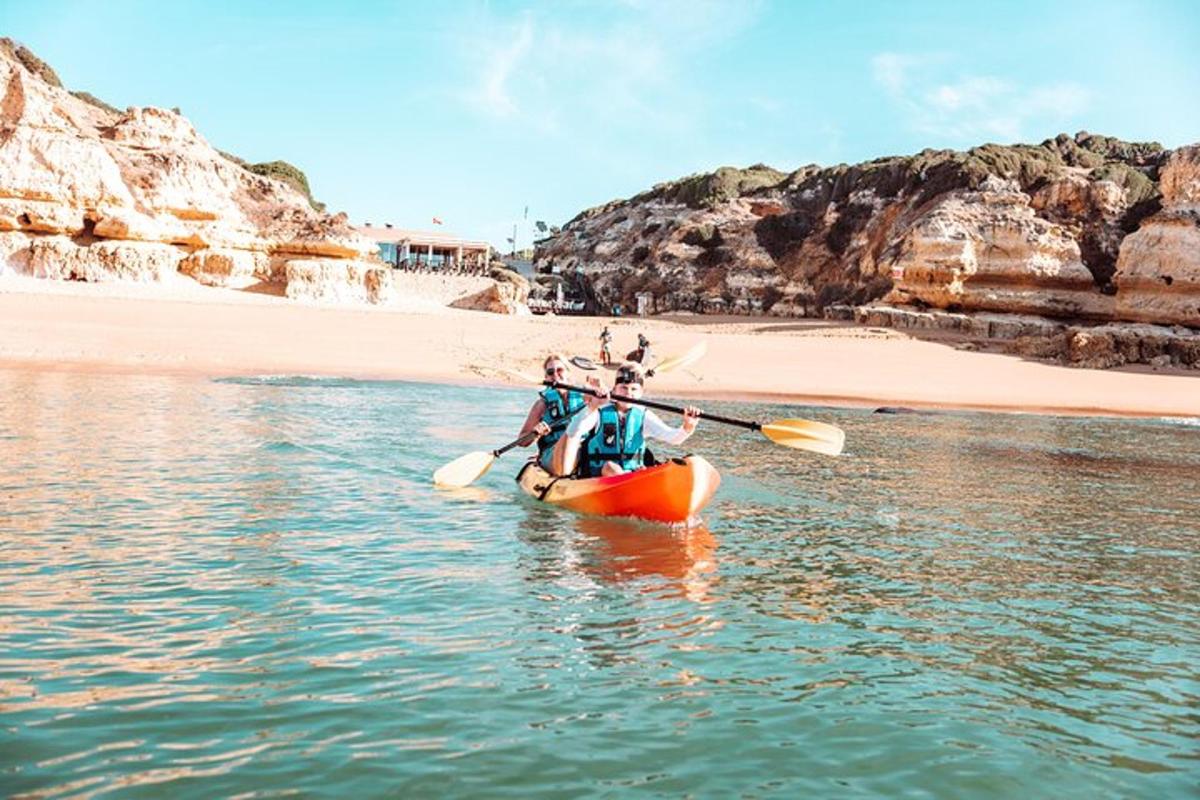 hai người trên một chiếc thuyền kayak ở dưới nước gần bãi biển
