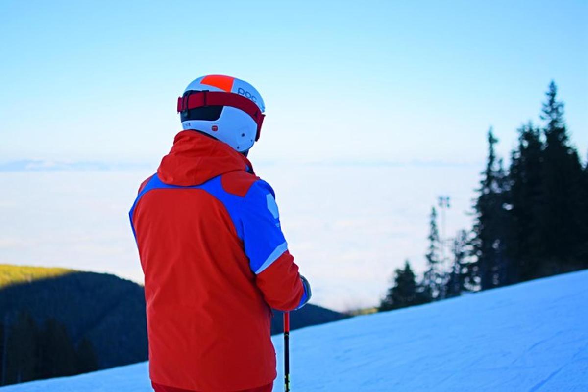 a person in a red jacket on skis in the snow