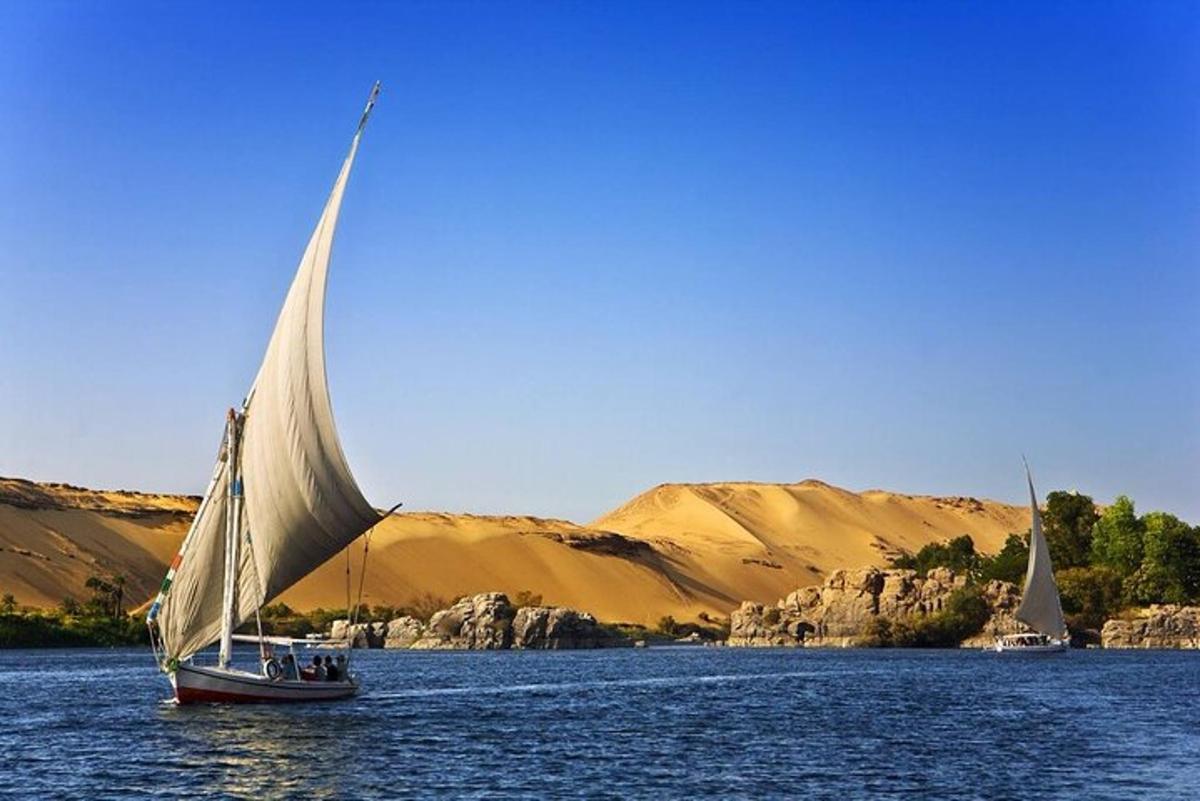 قاربين شراعيين على الماء مع الجبال في الخلفية