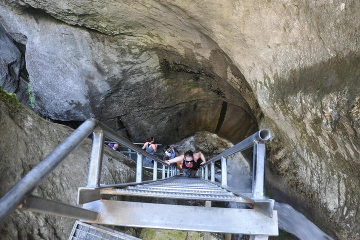 a group of people walking down a stairs in a cave