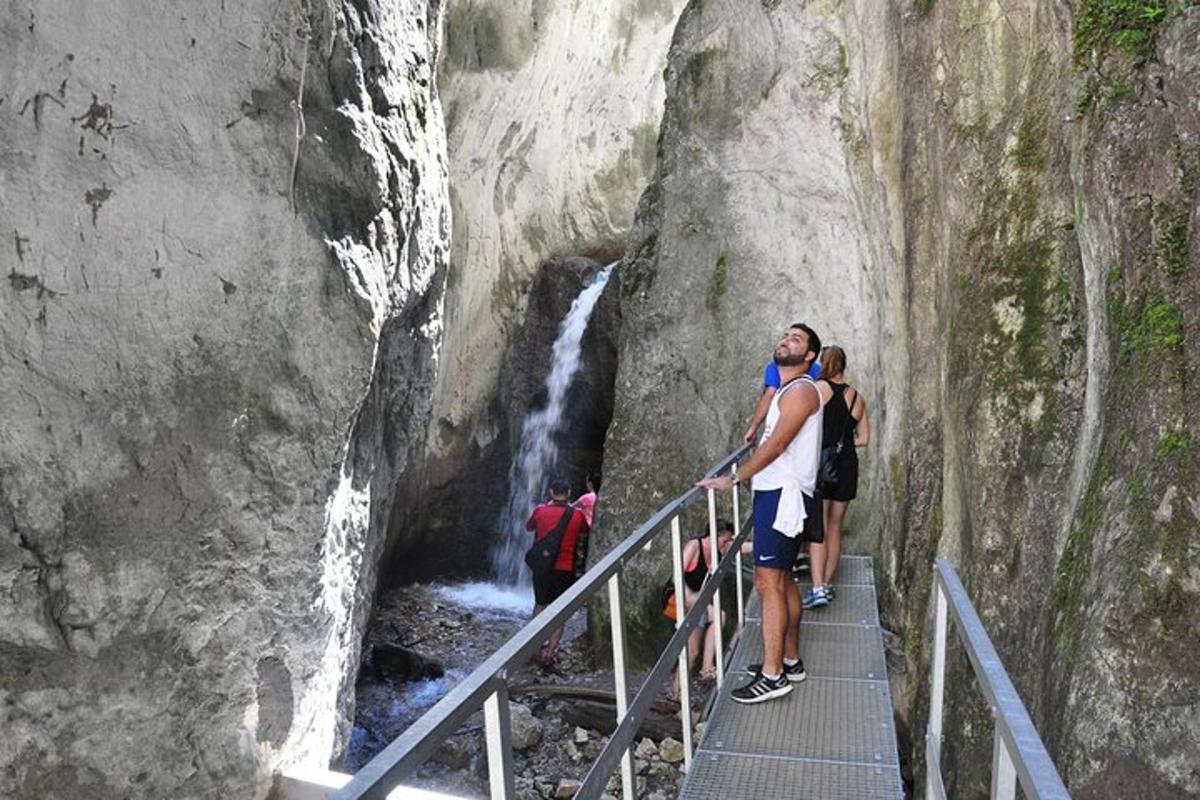 two people standing on a staircase near a waterfall