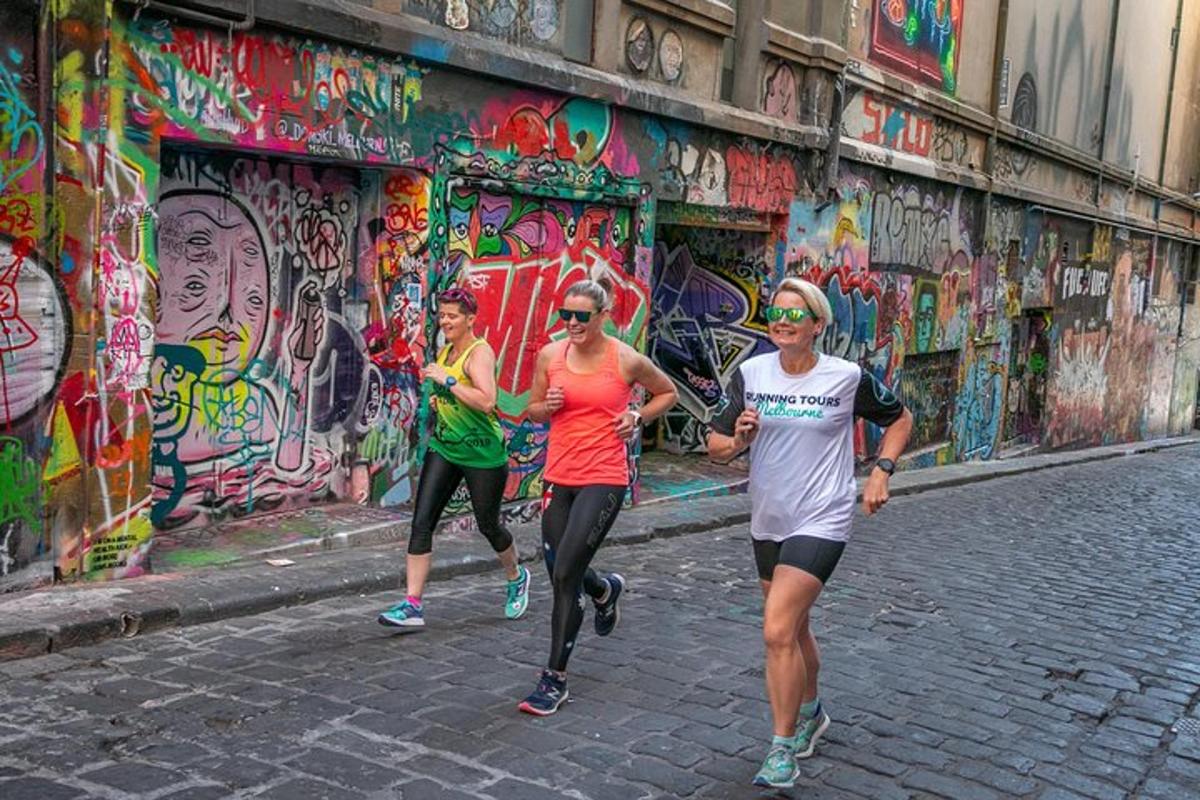 tre persone che corrono lungo una strada con graffiti