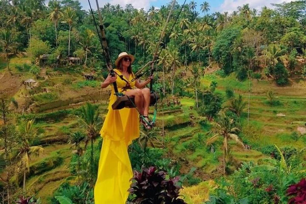 seorang wanita menaiki buaian di padang