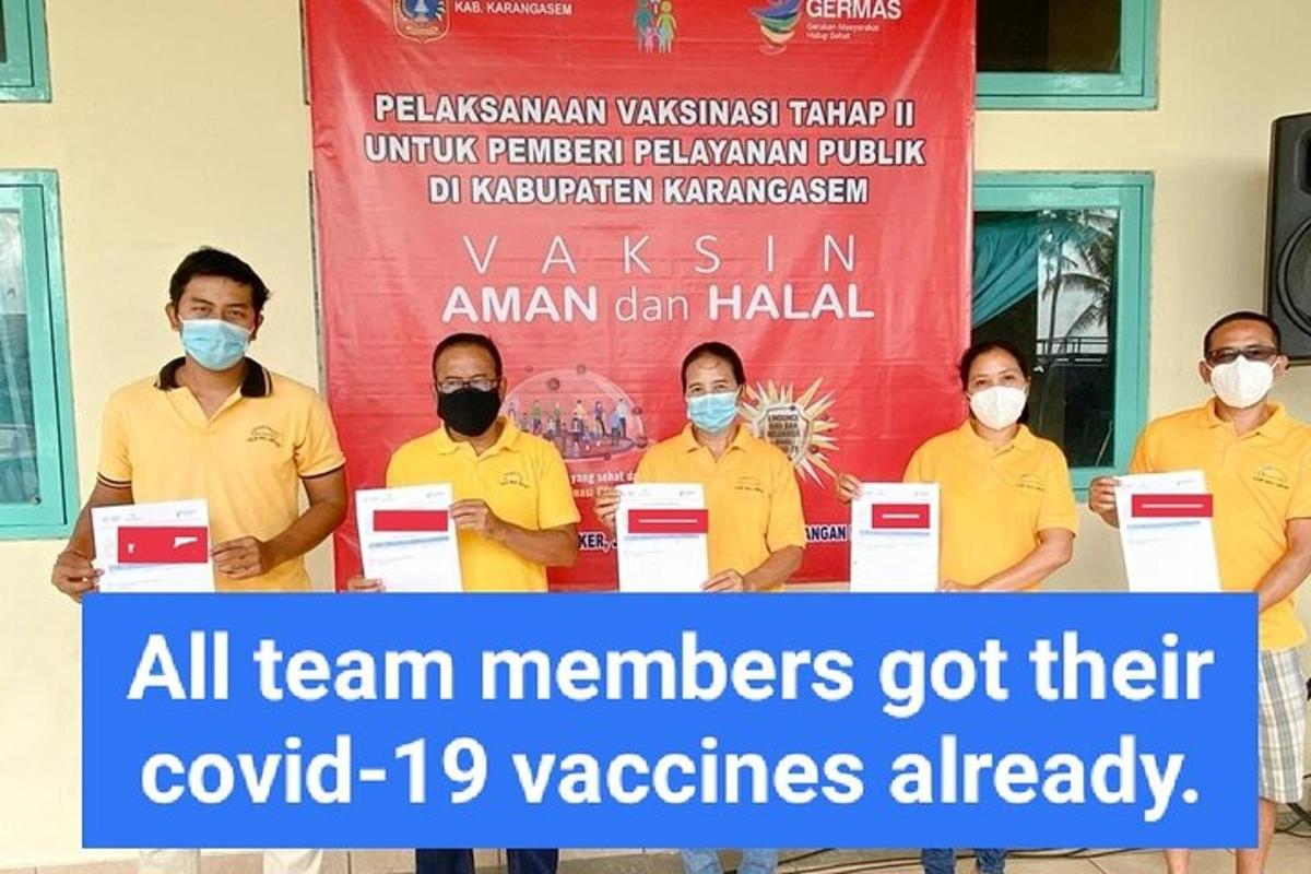 sekumpulan lelaki memakai topeng berdiri di hadapan sepanduk