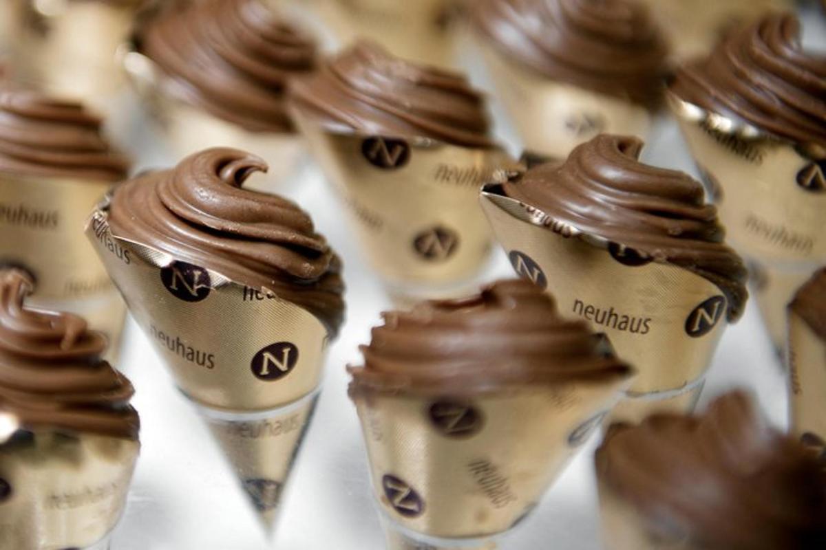 un gruppo di coni gelato immersi nel cioccolato
